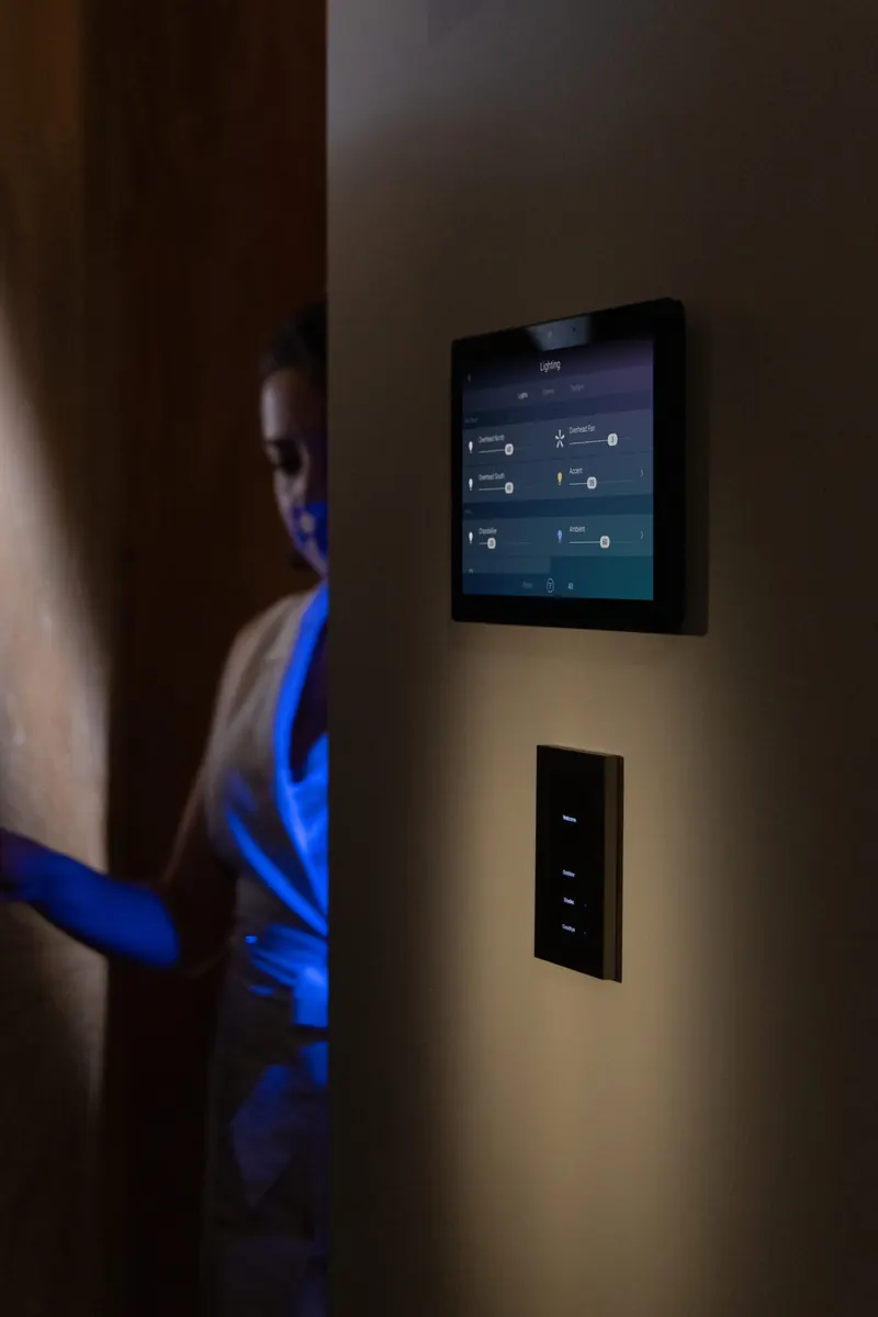 A softly lit hallway with a wall-mounted touch panel